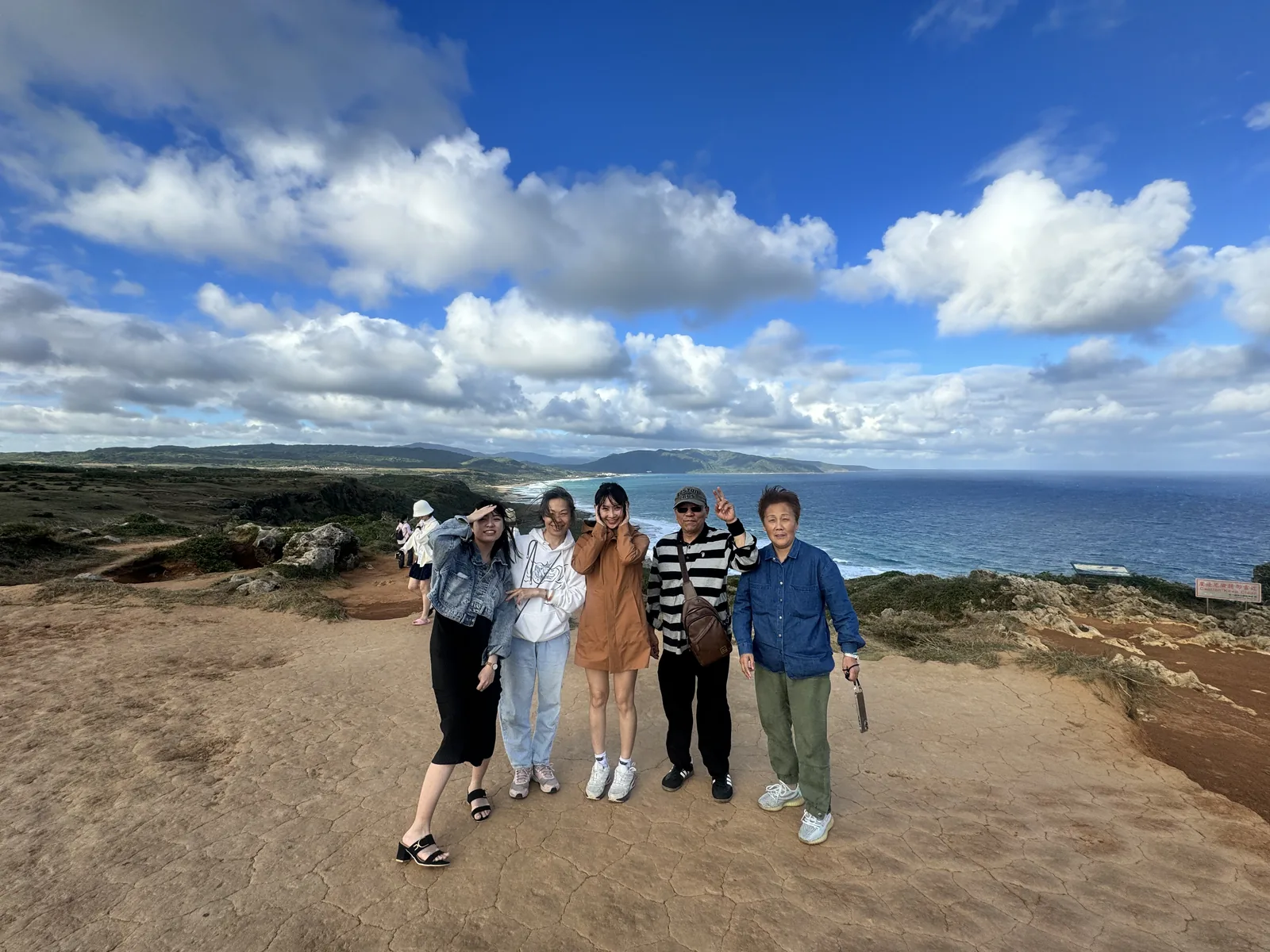 旅客在海岸岩地上合影